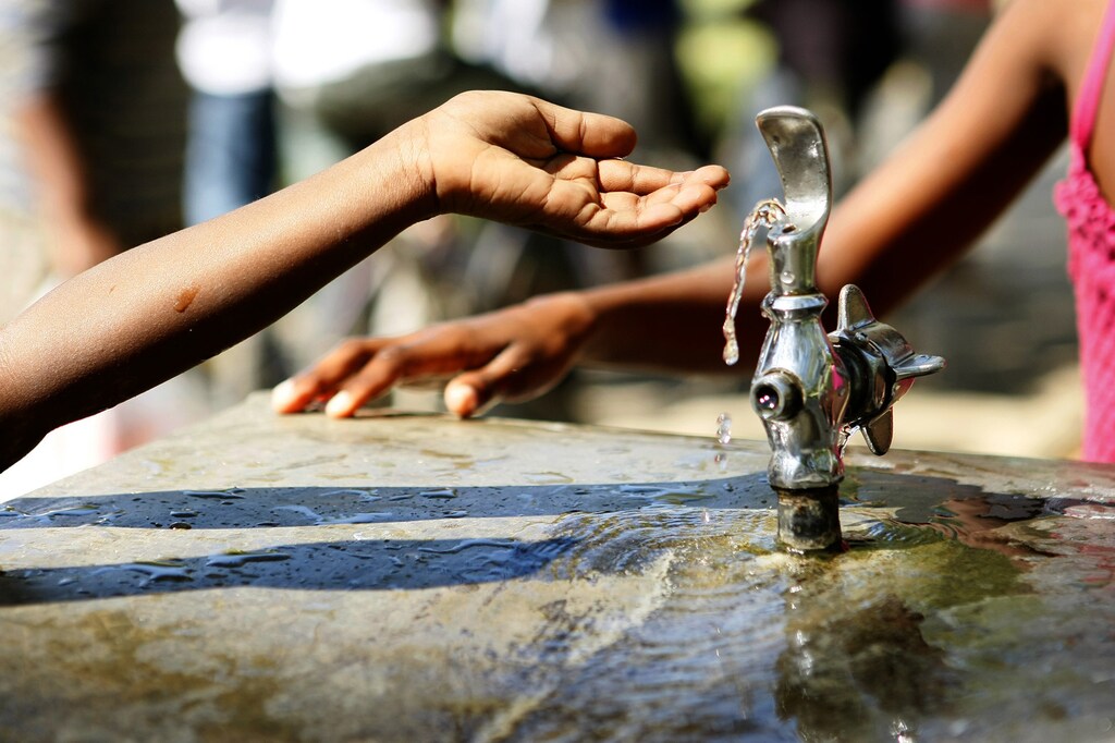 People gather around a working water fountain in the courtyard of a Christian mission on the outskirts of Port-au-Prince January 18, 2010. REUTERS/Ana-Bianca Marin