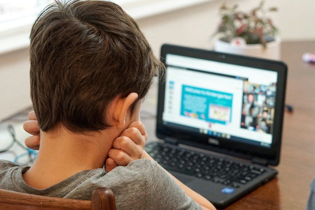 A child using a laptiop, illustrating the importance of online safety