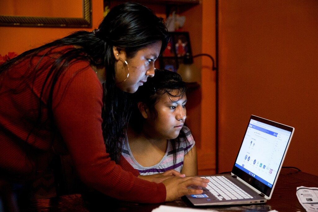 Belen Cruz tries to help her daughter, Natalie, log on to her school's online learning platform at their home in York, Pennsylvania, U.S. September 18, 2020. The online platform would not load for almost an hour, during which Natalie was not able to get any school work done. Picture taken September 18, 2020. REUTERS/Rachel Wisniewski - RC2B8J9V3GRJ