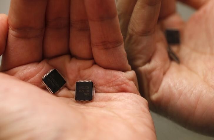 Renesas Electronics Corp's microcontroller chips are placed on a palm and reflected in a mirror in this illustrative photograph taken in Tokyo May 24, 2012. Japan's loss-making Renesas Electronics Corp said on Thursday it will tie up with Taiwan Semiconductor Manufacturing Co in the microchip business as it struggles to keep up with aggressive rivals like Samsung Electronics. REUTERS/Kim Kyung-Hoon (JAPAN - Tags: BUSINESS SCIENCE TECHNOLOGY)