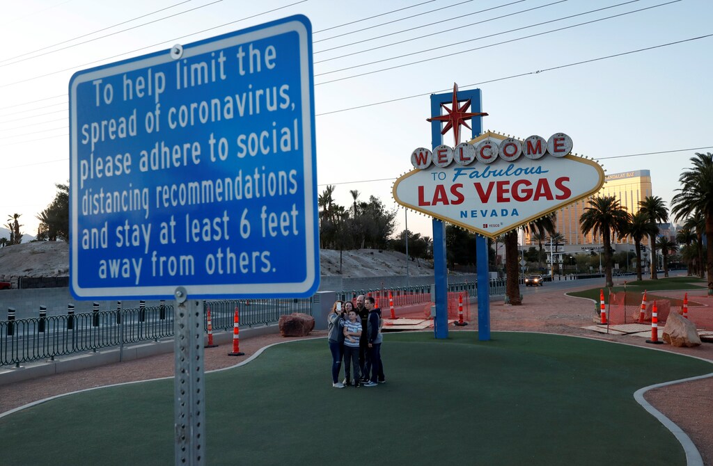 A family takes a selfie at the normally crowded "Welcome to Las Vegas" sign during the shutdown of all casinos and nonessential businesses, an effort to slow the spread of the novel coronavirus, in Las Vegas, Nevada, U.S. April 3, 2020. REUTERS/Steve Marcus - united states us america economics unemployment jobs security recession redundant women business businesswoman businessman corporation corporate finance wall street stock exchange capitalism