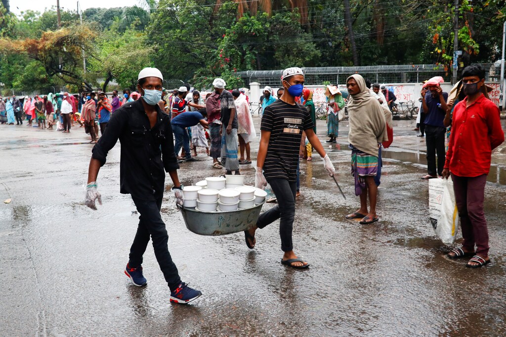 Volunteers carry iftar meals to distribute among poor people during ramadan amid the coronavirus disease (COVID-19) outbreak in Dhaka, Bangladesh, April 28, 2020. REUTERS/Mohammad Ponir Hossain - RC2PDG9T36D4