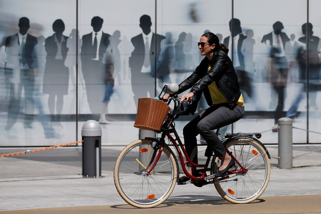 A woman rides a bicycle past a building of the European Commission in Brussels, Belgium June 14, 2017. REUTERS/Francois Lenoir - RTS171XQ