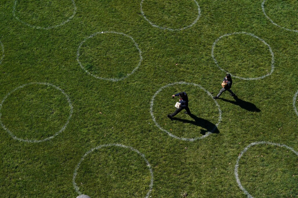 People walk through a city park marked with social distancing circles as some restrictions are eased for fully-vaccinated residents during a lockdown to curb the spread of a coronavirus disease (COVID-19) outbreak in Sydney, Australia, September 22, 2021. REUTERS/Loren Elliott - RC2SUP95RC0O