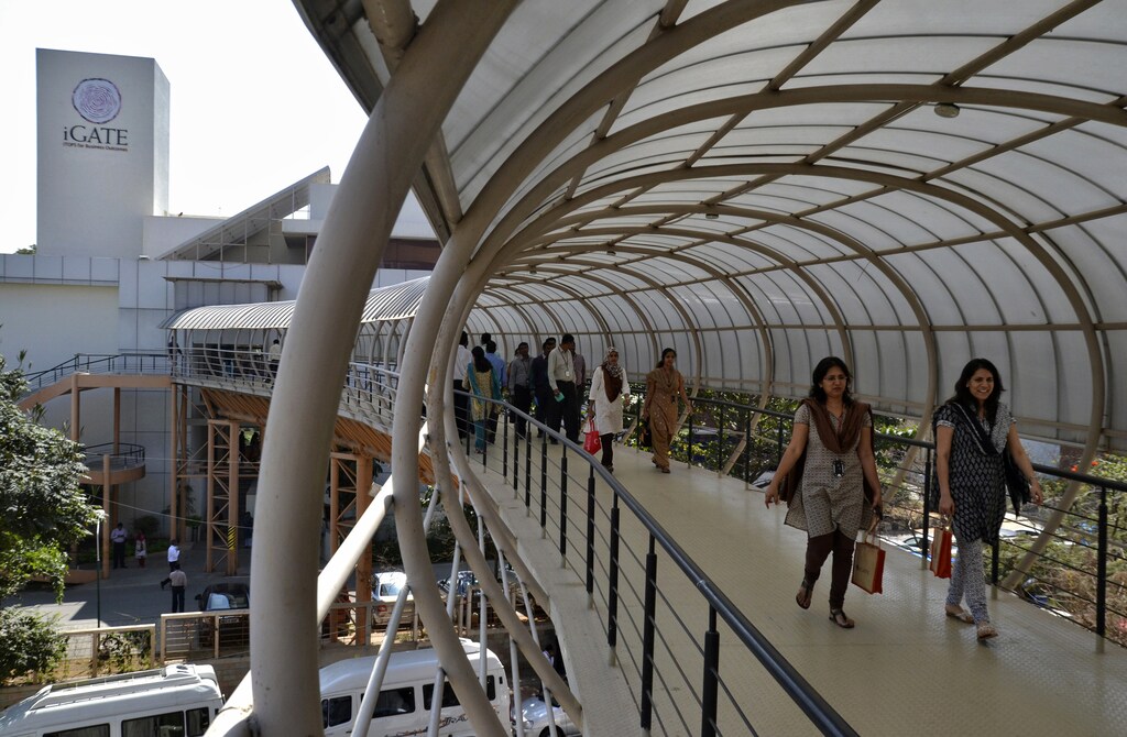 Employees cross an overpass at the Indian headquarters of iGate in the southern Indian city of Bangalore February 4, 2013.