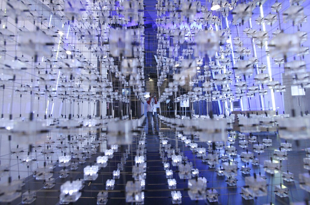A museum staff member takes photos of an artwork named "3D Display Cube" by James Clar during a media preview at the National Museum of Emerging Science and Innovation (Miraikan) in Tokyo April 23, 2008.