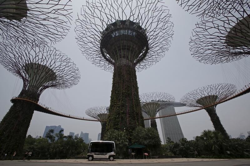 An autonomous self-driving vehicle picks up people during a demonstration at Gardens by the Bay in Singapore October 12, 2015. Singapore unveiled its public transport future on Monday, and it was a vision of passengers commuting in driverless buses along roads and freeways populated by platoons of autonomous trucks following a single driver. REUTERS/Edgar Su - GF10000241787