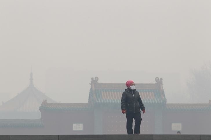A woman wearing a mask walks outside the old palace museum on a hazy day in Shenyang, Liaoning province, November 8, 2015. As winter heating started in the city, the reading of PM2.5 was more than 1000 micrograms per cubic metre on Sunday, according to local media. Picture taken November 8, 2015. REUTERS/Stringer CHINA OUT. NO COMMERCIAL OR EDITORIAL SALES IN CHINA