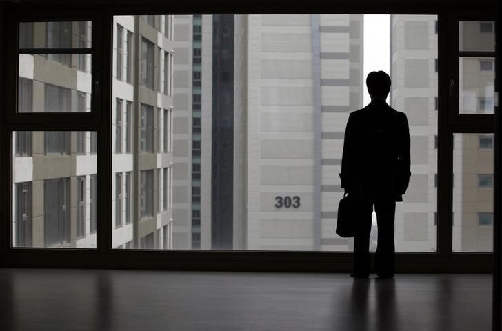Kim Keon-hoon, a worker with Byucksan Engineering & Construction, looks out through the window from his empty two-bathroom, four-bedroom apartment before an interview with Reuters, in the middle class suburb in Goyang, north of Seoul April 1, 2013. Kim says he was forced to buy an unsold 800 million won ($716,400) apartment, built by his employer in 2008, as the company teetered on the edge of bankruptcy. Five years after the global financial crisis, South Korean construction workers are feeling the pinch more than ever as they shoulder a mountain of debt from a real estate bust that has cast a long shadow on the country's growth prospects. Picture taken April 1, 2013. REUTERS/Lee Jae-Won (SOUTH KOREA - T