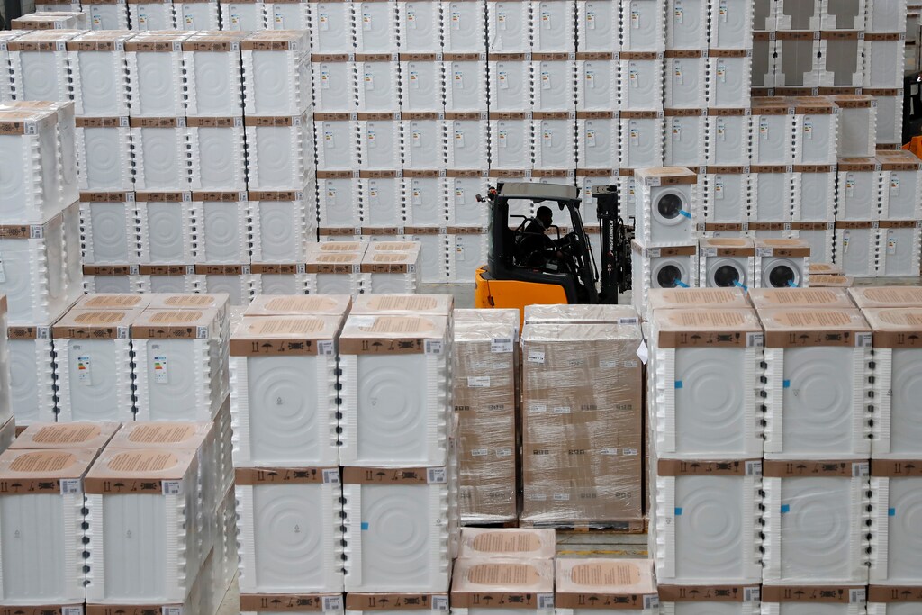 A forklift drives among washing machines stocked in a warehouse of BSH Electromenager in Tournan en Brie, southeast of Paris, France, October 26, 2017. Picture taken October 26, 2017. REUTERS/Gonzalo Fuentes - RC19F1628650