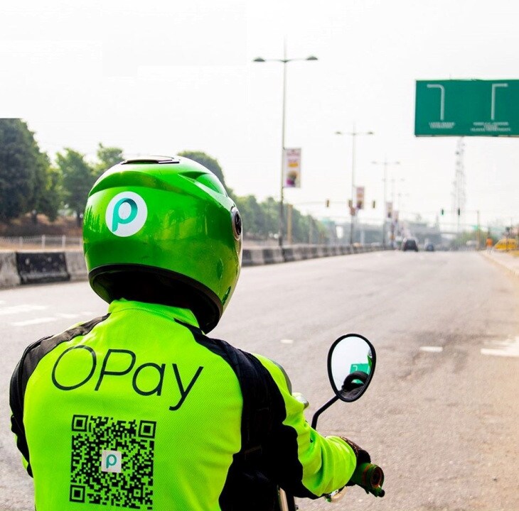A person driving a motorbike in an OPay uniform