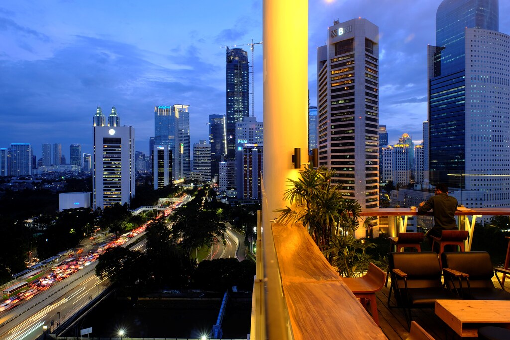 A man sits at a roof top restaurant during sunset in Jakarta, Indonesia, March 30, 2017.