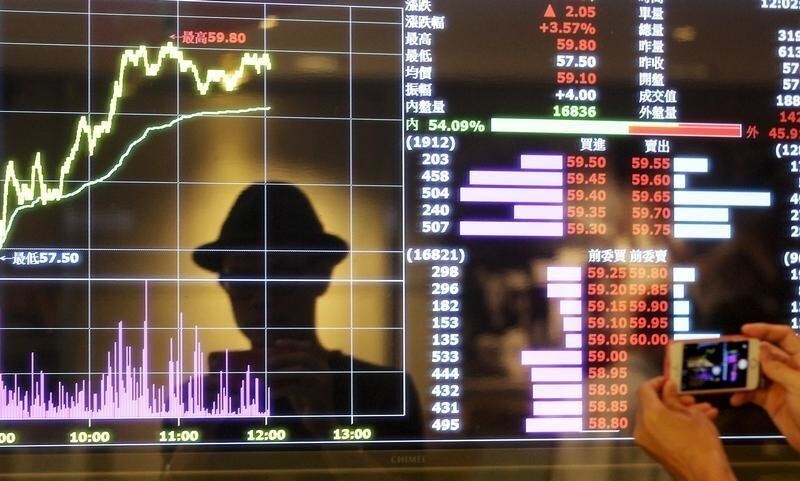 A man takes pictures with his smartphone at a screen showing stock market prices inside a brokerage in Taipei, Taiwan, August 25, 2015. Taiwan stocks rebounded from steep losses in the prior session on hopes the government would soon step in to shore up market confidence after the key index plunged to a near three-year low on Monday. REUTERS/Pichi Chuang TPX IMAGES OF THE DAY - RTX1PJIL