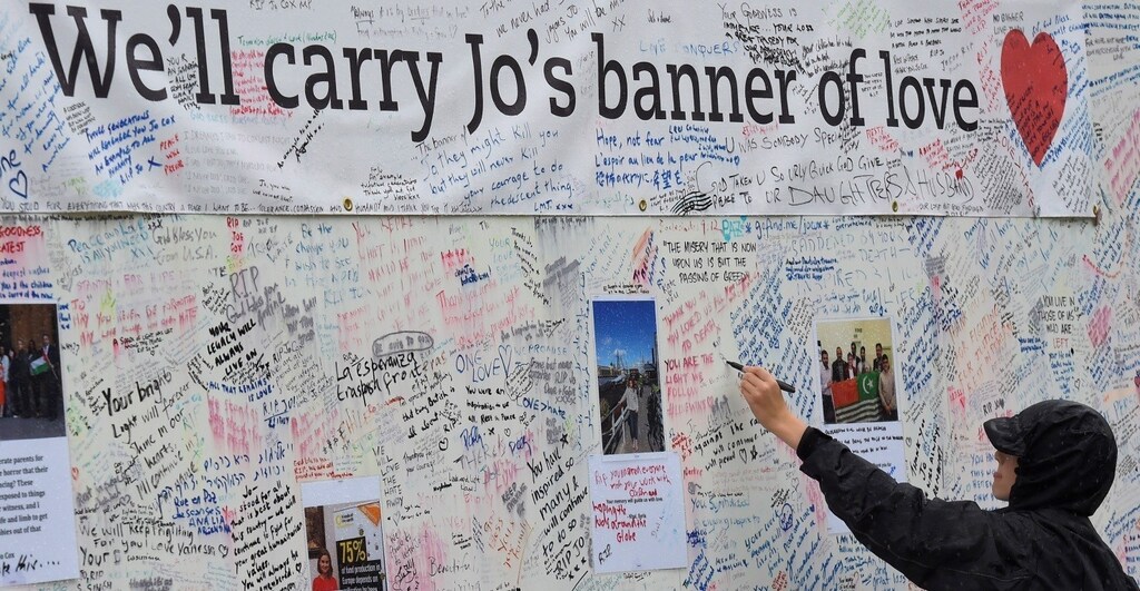 A man writes a tribute on a message board erected in memory of murdered Labour Party MP Jo Cox, who was shot dead in Birstall, at Parliament Square in London