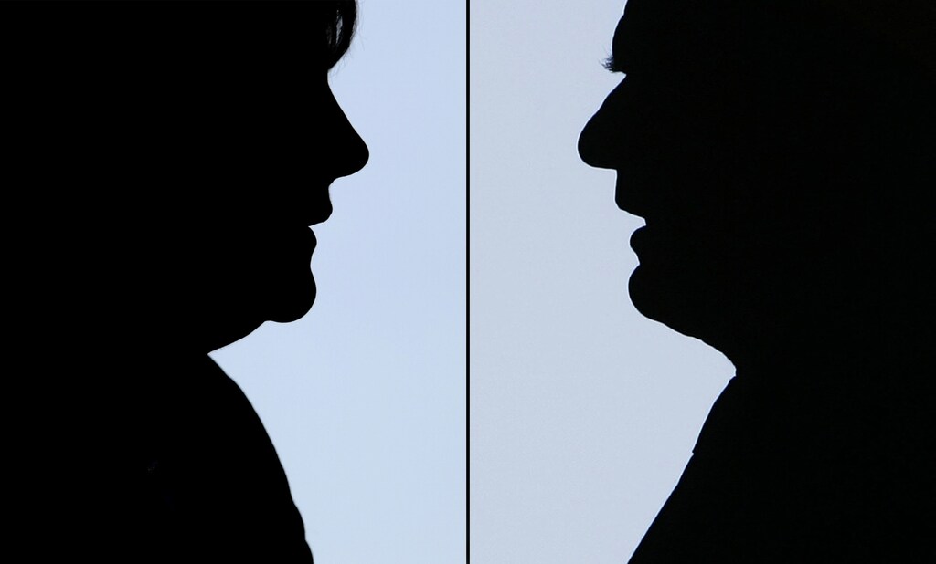 A September 2, 2005 combination of two file photos shows silhouettes of German Chancellor Gerhard Schroeder as he speaks to shipyard workers in Wismar August 22, 2005, and Angela Merkel, Christian Democratic Union's (CDU) top candidate for the upcoming general elections (L) during her speech at an election campaign rally in Karlsruhe August 31, 2005. Chancellor Gerhard Schroeder gets a last chance to turn around his troubled election campaign on Sunday when he confronts his conservative rival Angela Merkel in a U.S.-style TV debate that will lure viewers across Germany. TO ACCOMPANY STORY GERMANY-ELECTION-DEBATE REUTERS/Alex Grimm and Christian Charisius/file photos CHA/AA - RP6DRMZZXUAB