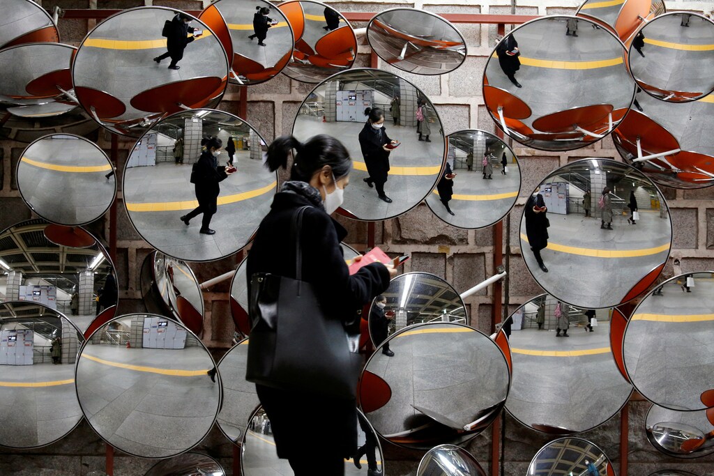 A woman wearing a mask to prevent the coronavirus is reflected in the mirrors, in Seoul, South Korea, February 24, 2020. REUTERS/Heo Ran TPX IMAGES OF THE DAY - RC2U6F9QKCLK