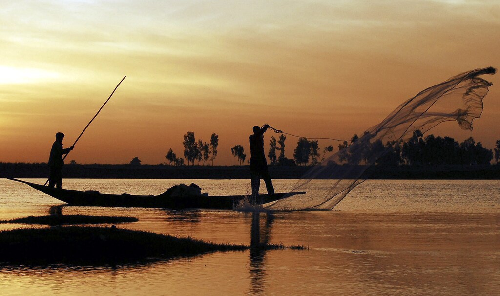 A Bozo fisherman casts his net from a pirogue in front of Saaya village in the Niger river inland delta February 7, 2007. The Bozo, a West African ethnic group located predominantly along the Niger River in Mali, are famous for their fishing skills and are locally occasionally referred to as the "masters of the river". Picture taken on February 7, 2007. REUTERS/Florin Iorganda (MALI) - RTR1M4GU