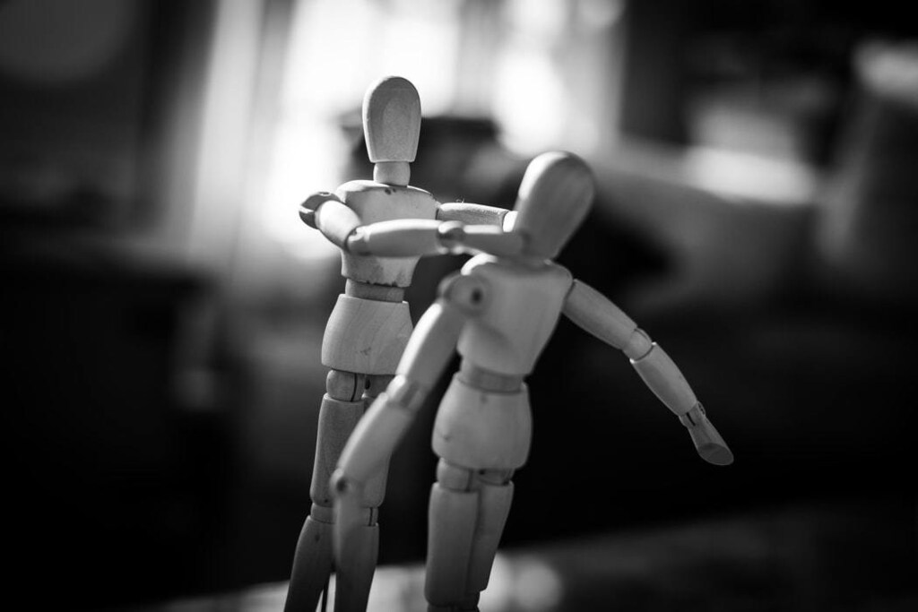 A picture of two stick figurines, one with its hands around the others neck, depicting a violent scene.