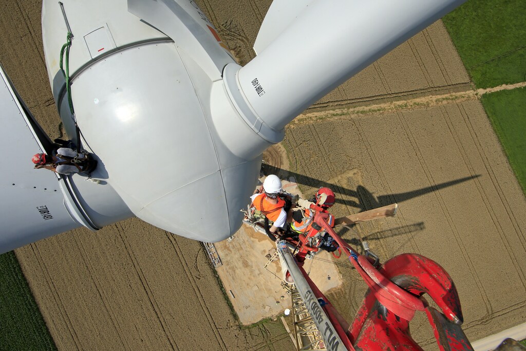 Employees work on a crane above an E-70 wind turbine manufactured by German company Enercon for La Compagnie du Vent (GDF SUEZ Group) during its installation at a wind farm in Meneslies, Picardie region, July 31, 2014. France announced in July a package of tax breaks and low-cost loans to improve insulation in buildings and boost investment in renewable energy, which is supposed to provide 40 percent of the country's electricity by 2030. Picture taken July 31, 2014. REUTERS/Benoit Tessier (FRANCE - Tags: ENERGY BUSINESS CONSTRUCTION ENVIRONMENT) - PM1EA841ETF01