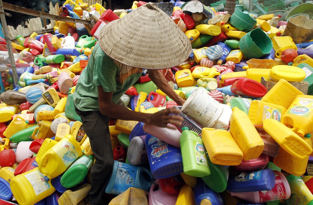 A man climbs on a pile of recyclable scrap materials at Xa Cau village, about 40 km (25 miles) south of Hanoi June 18, 2013. According to Nguyen Van Thanh, a local vendor in the village, more than 90 percent of Xa Cau village, with about 1,000 families, have switched their traditional profession from making bamboo tooth picks to dealing with recyclable materials, in the past three years. Recyclable materials from Hanoi, around 30 tonnes, is sent to the village daily, Nguyen said. REUTERS/Kham
