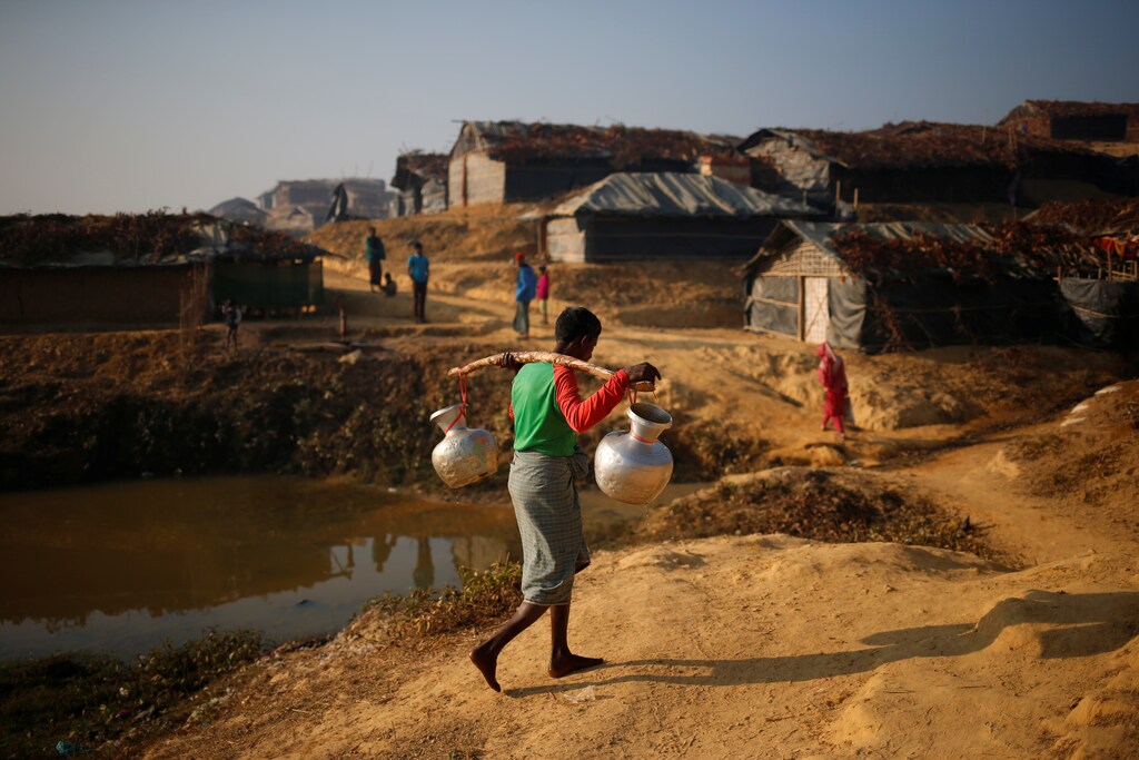A Rohingya refugee man carries water on his shoulder in the morning at Kutupalang Unregistered Refugee Camp, in Cox's Bazar, Bangladesh, February 4, 2017. REUTERS/Mohammad Ponir Hossain - RTX2ZM7A
