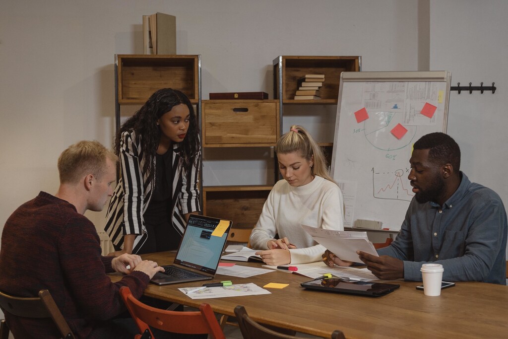 A female leader talking to her fellow work colleagues in the workplace.