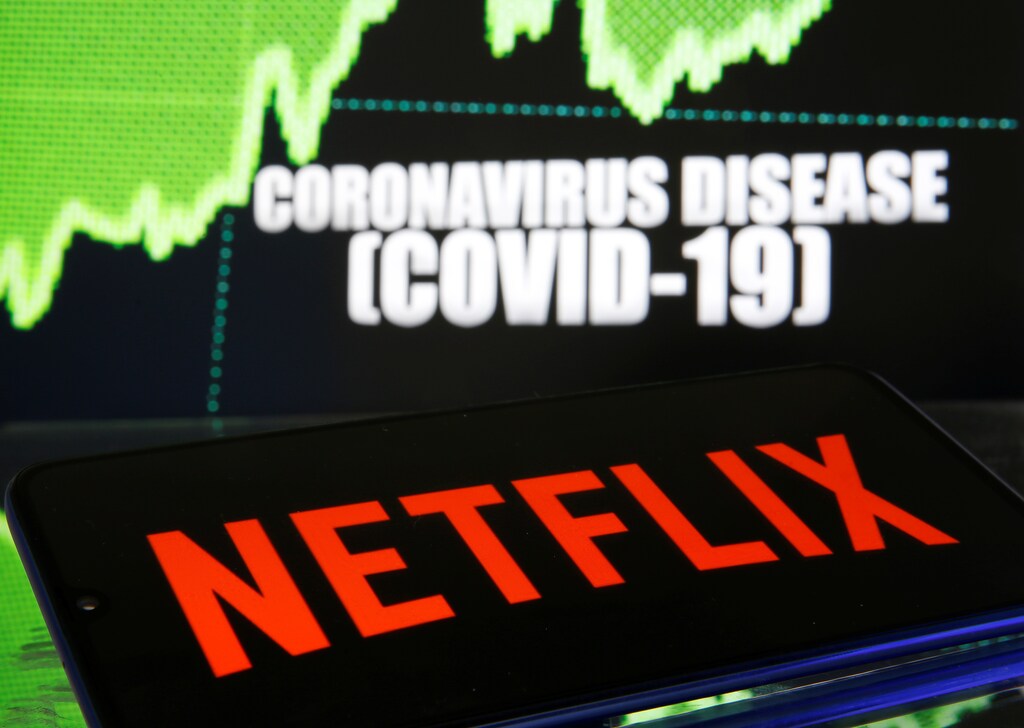 Netflix logo is seen in front of diplayed coronavirus disease (COVID-19) in this illustration taken March 19, 2020.
