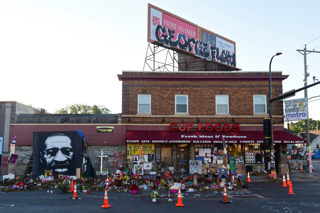 A memorial to George Floyd, who died after a white Minneapolis police officer pressed his knee into his neck on May 25, is lit by morning light outside Cup Foods one month later in Minneapolis, Minnesota, U.S. June 25, 2020. REUTERS/Nicholas Pfosi - RC2CGH9DWS1U