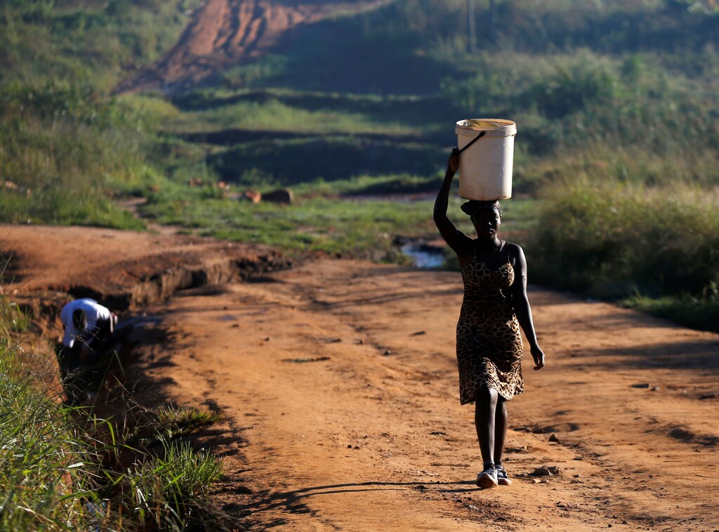 Women fetch water from a stream after Cyclone Idai in Chipinge, Zimbabwe, March 25,2019. REUTERS/Philimon Bulawayo - RC1AF83299C0