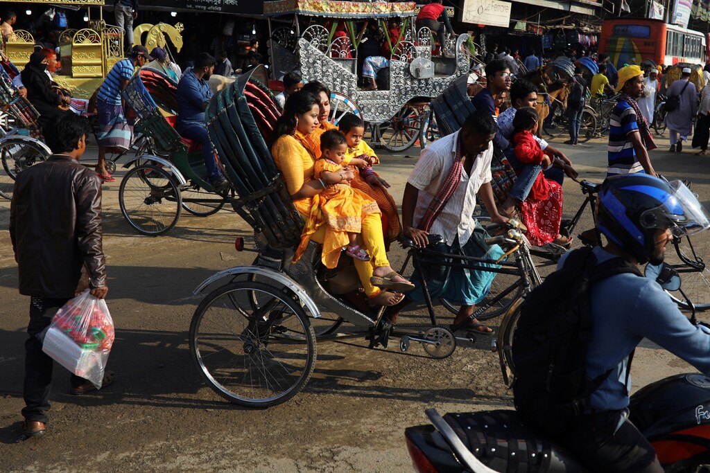 Commuters wearing colourful clothes ride on rickshaws in Dhaka, Bangladesh, February 13, 2020. REUTERS/Mohammad Ponir Hossain - RC2NZE9OJ4VX