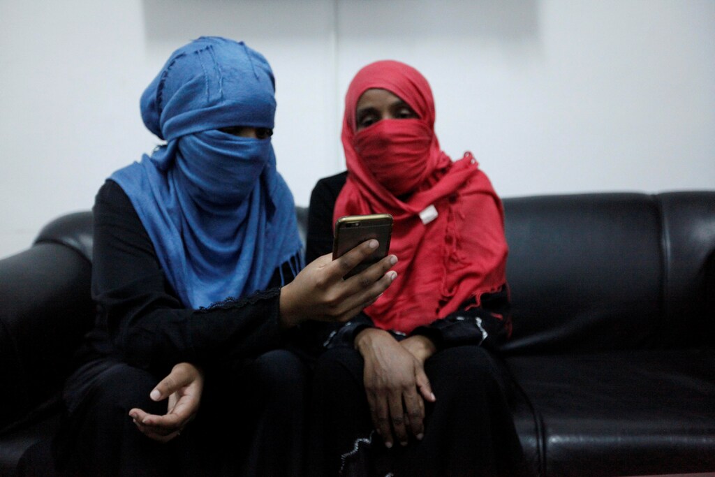 Eritrean migrants in Misrata, Libya look at a smartphone.