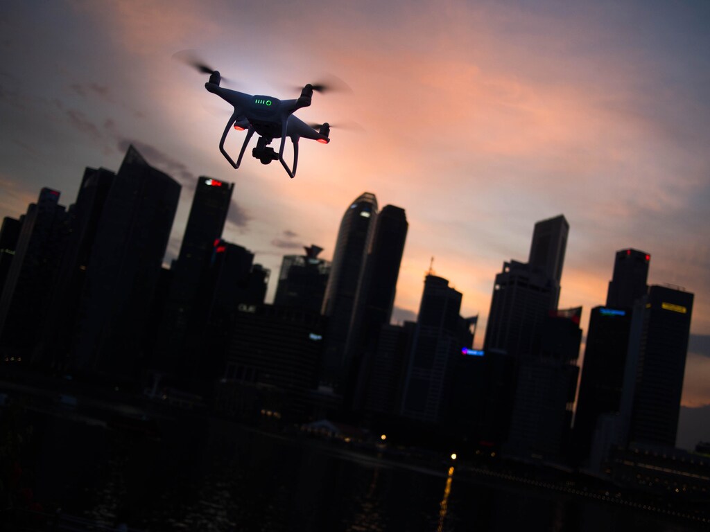 An airborne drone heading towards a city