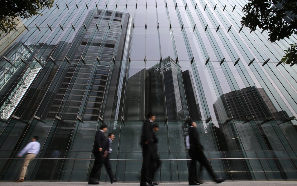 Businessmen walk in Tokyo's business district April 1, 2013. Japanese business sentiment improved in the first three months of 2013.