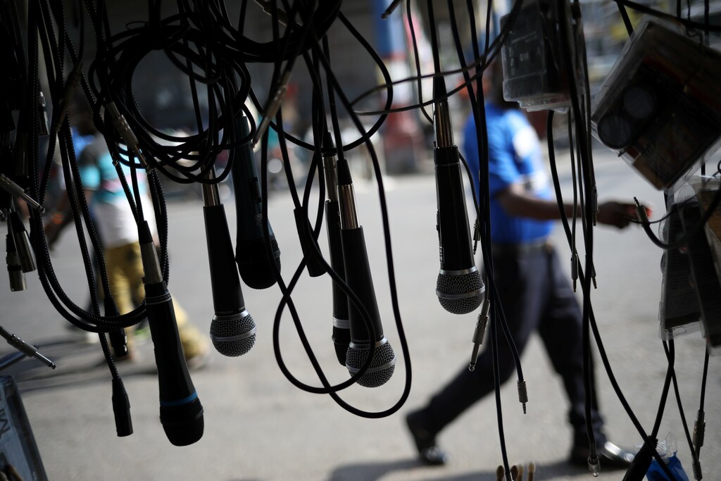 A man walks next to microphones put set on display for sale in a street of Port-au-Prince, Haiti, April 2, 2018. REUTERS/Andres Martinez Casares - RC171A4B0CC0