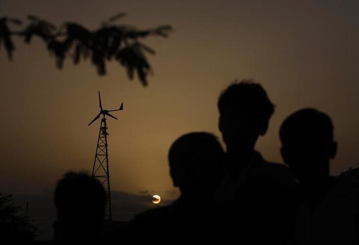 Children are silhouetted near a wind turbine generator that produces energy for a village at Hub about 25 km (15 miles) northwest of Karachi June 18, 2010. Pakistan this year expects to finalise four wind power deals worth $500 million, to exploit a renewable resource that has been barely tapped in a country with a yawning gap between power capacity and demand. To match interview PAKISTAN-ENERGY/ REUTERS/Akhtar Soomro (PAKISTAN - Tags: BUSINESS ENVIRONMENT ENERGY IMAGES OF THE DAY)