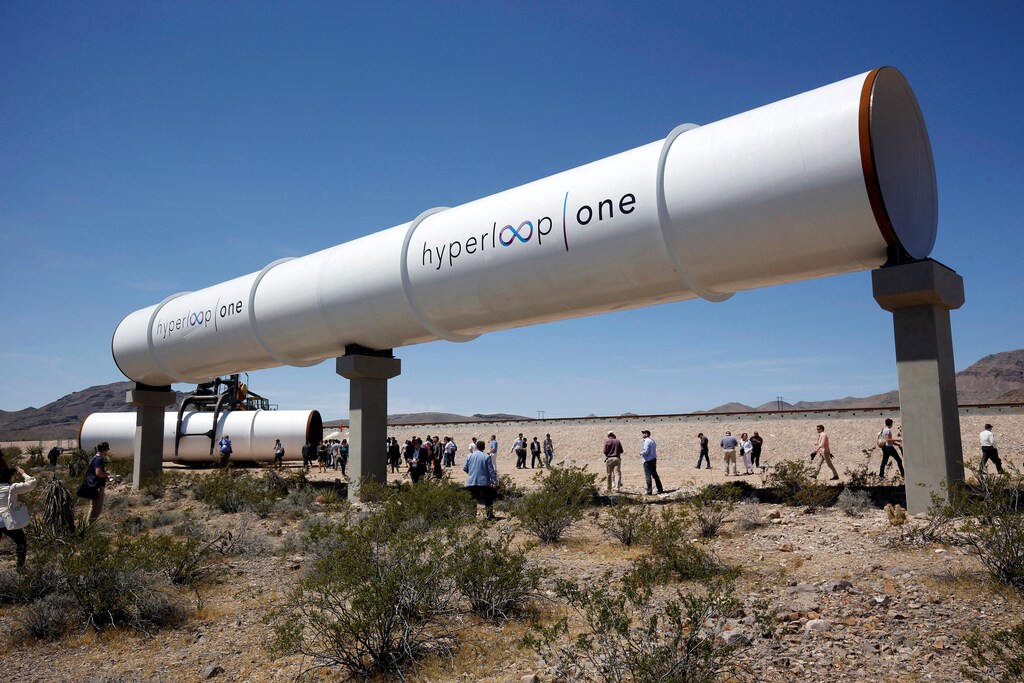 Journalists and guests look over tubes following a propulsion open-air test at Hyperloop One in North Las Vegas, Nevada, U.S. May 11, 2016. REUTERS/Steve Marcus - RTX2DWFB
