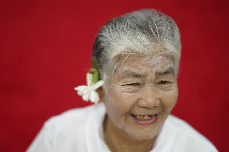 An elderly woman smiles at a temple in Ayutthaya, Thailand March 7, 2018. Picture taken March 7, 2018.