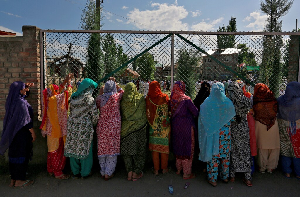 Women in Srinagar watch a demonstration against the recent killings in the region as the city remains under curfew following weeks of violence in Kashmir, August 19, 2016. REUTERS/Cathal McNaughton - RTX2M0C4