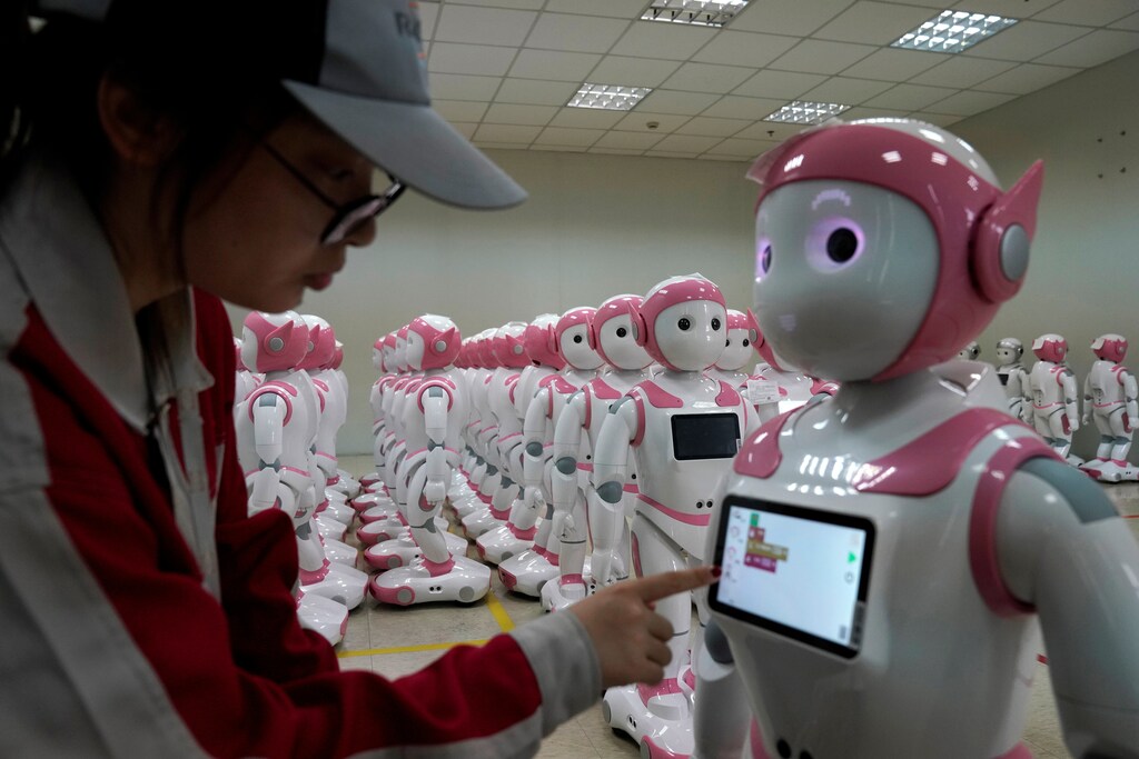 A worker puts finishing touches to an iPal social robot, designed by AvatarMind, at an assembly plant in Suzhou, Jiangsu province, China July 4, 2018. Designed to offer education, care and companionship to children and the elderly, the 3.5-feet tall humanoid robots come in two genders and can tell stories, take photos and deliver educational or promotional content. Picture taken July 4, 2018.REUTERS/Aly Song - RC1B1450D2B0