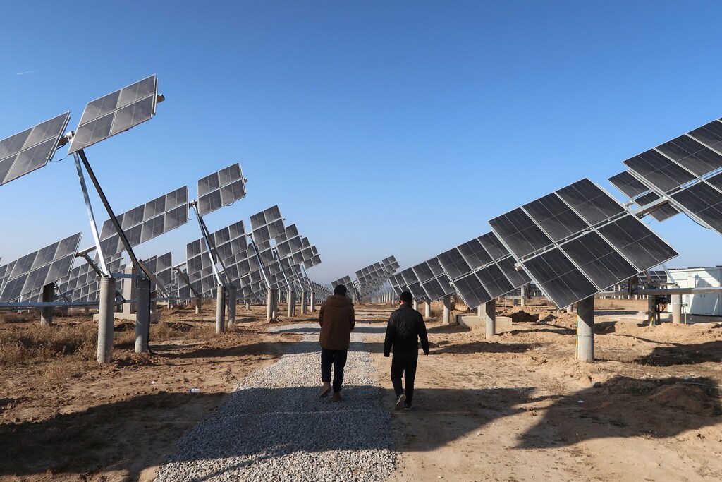 Workers walk at a solar power station in Tongchuan, Shaanxi province, China December 11, 2019. Picture taken December 11, 2019. REUTERS/Muyu Xu - RC2JXD9H0H3R