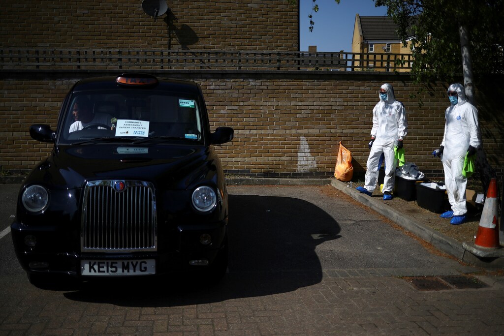 Workers from cleaning company Dropless wait to sanitise a London Black Cab as part of a service between taxi platform Gett and the NHS in south east London to ensure patients with COVID-19 symptoms can get to a local GP without using public transport as the spread of the coronavirus disease (COVID-19) continues, in London, Britain, April 23, 2020. REUTERS/Hannah Mckay - RC2FAG952KYV