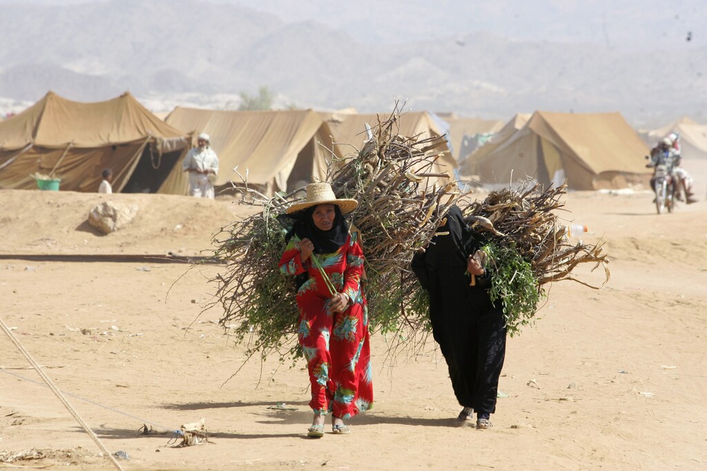 Women carry firewood in al-Mazraq refugee camp near the northwestern Yemeni province of Saada November 12, 2009. Around 8,000 people live in the camp near the Saudi border, after they fled battles raging between the army and Shi'ite rebels in northern Yemen for the past three months. REUTERS/Khaled Abdullah (YEMEN CONFLICT POLITICS) - GM1E5BC1U2O01