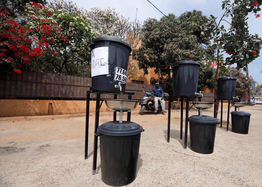 Thierno Seck, 36, who says he is a plumbing designer, sits on his scooter as he sells handwashing stations he made, amid the coronavirus disease (COVID-19) outbreak in Dakar, Senegal April 14, 2020. REUTERS/Zohra Bensemra - RC2J4G9VPJ20
