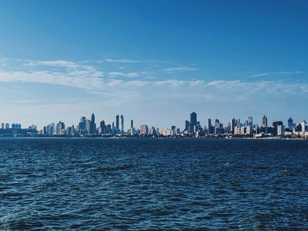 Una gran masa de agua con una ciudad al fondo; Mumbai, Maharashtra, India; ciudades positivas para la naturaleza.