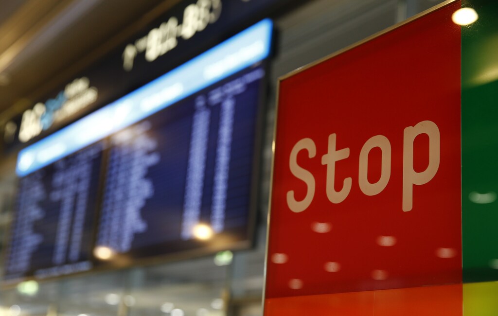 A sign reading Stop stands in front of an electronic information board following a security alert at Cologne airport, in Cologne, Germany