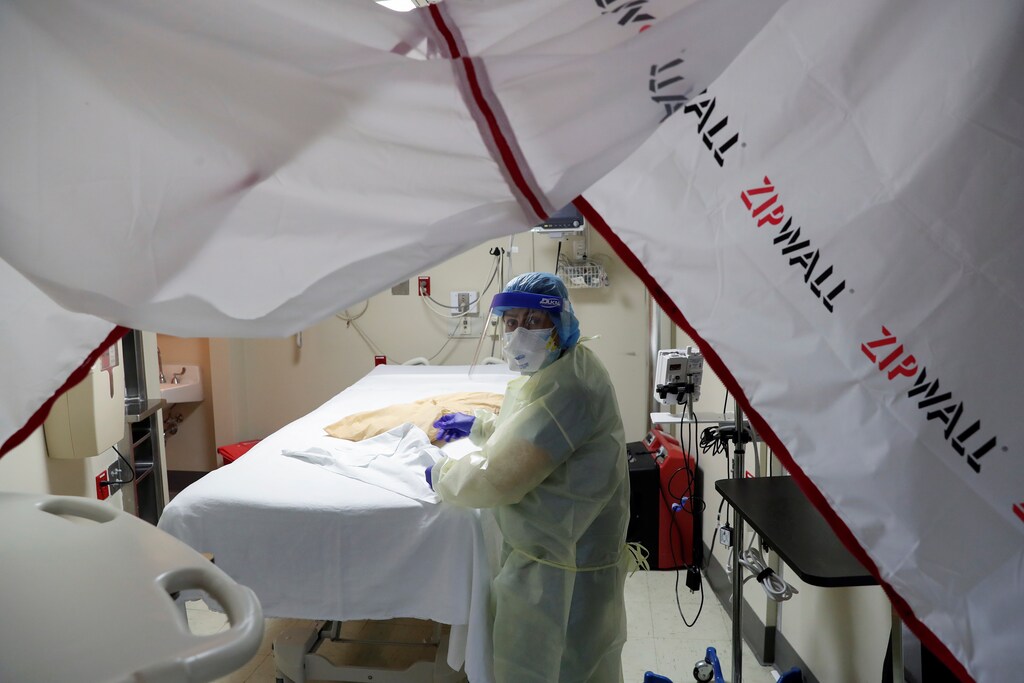 Evelia De La Cruz, a hospital housekeeper at Roseland Community Hospital, disinfects the room where a coronavirus disease (COVID-19) positive patient died on the South Side of Chicago, Illinois, U.S., December 1, 2020. REUTERS/Shannon Stapleton - RC2OEK93KGF7