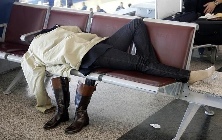 A passenger sleeps on a bench at the Fiumicino International airport in Rome November 11, 2008. Dozens of Alitalia flights were cancelled for a second day on Tuesday after protests by airline staff opposed to a takeover by a business consortium had forced the cancellation of about 100 flights on Monday, with the government threatening tough action against the strikers. REUTERS/Max Rossi (ITALY)