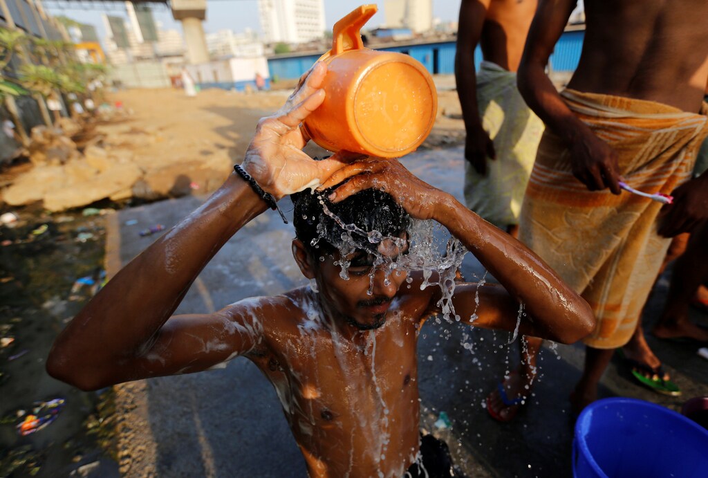 A labourer takes a bath at a communal tap in Mumbai, India, March 22, 2017. REUTERS/Danish Siddiqui - RTX3235O