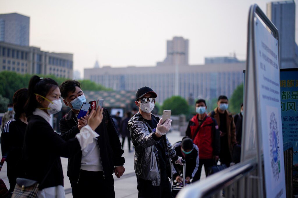 People scan a health QR code at Wuhan's Hankou Railway Station as travel restrictions for leaving the city, the epicentre of a global coronavirus disease (COVID-19) outbreak, are lifted and people will be allowed to leave the city via road, rail and air, in Wuhan, Hubei, China April 8, 2020. REUTERS/Aly Song - RC200G9BH9ZX