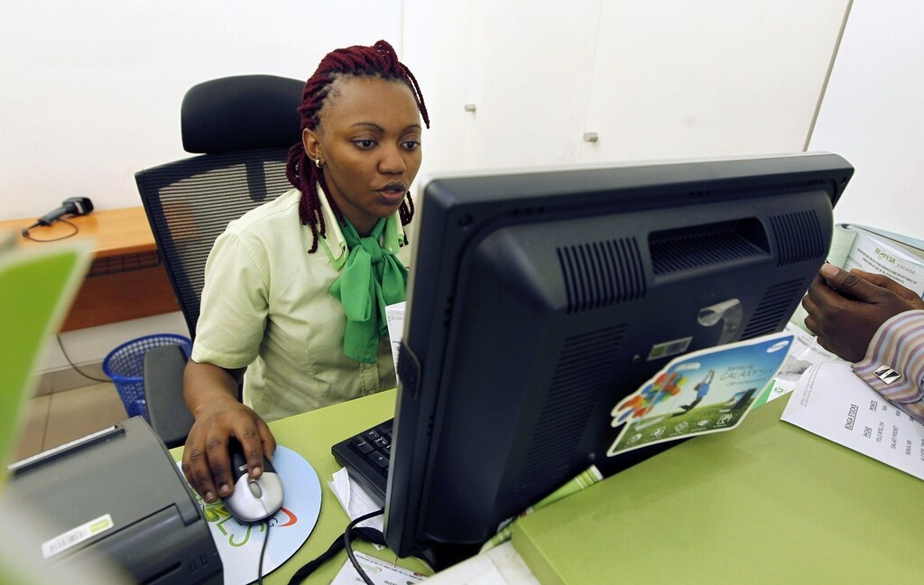 An employee registers a customer for a mobile money transfer, known as M-Pesa, inside the Safaricom mobile phone care centre in the central business district of Kenya's capital Nairobi July 15, 2013. To match Insight AFRICA-MOBILEMONEY/ Picture taken July 15, 2013. REUTERS/Thomas Mukoya (KENYA - Tags: BUSINESS TELECOMS) - RTR40NWM